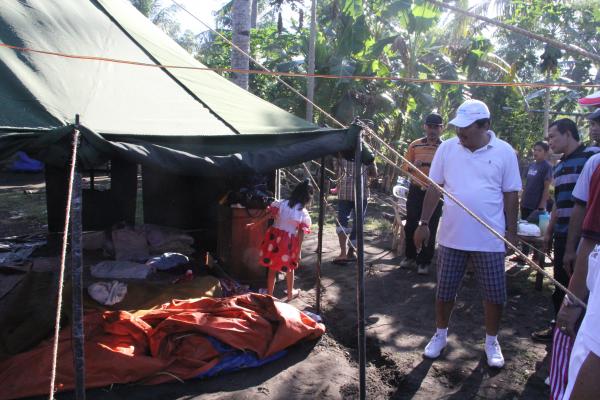 Keprihatinan Bupati Putu Artha melihat korban terjangan ombak Candiksuma di tenda pengungsian.